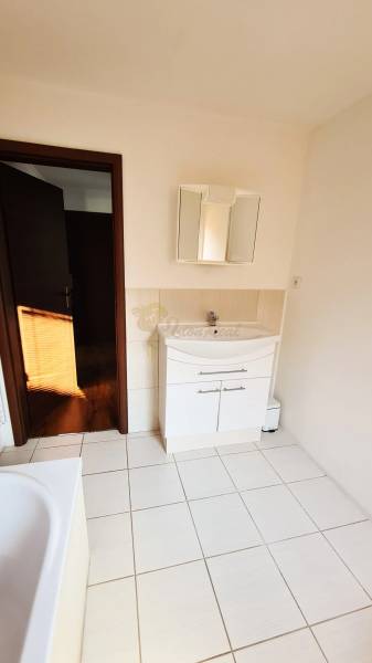 5-izb. dvojpodlažný rodinný dom, Rovinka - Kúpeľňa v rodinnom dome s bielou umývadlovou skriňou a obkladmi.