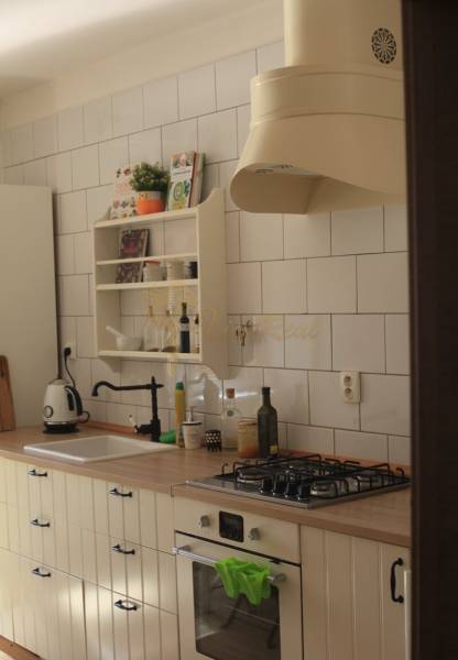 Veľký 2-izb. byt v tehlovom dome, Ružová dolina, Ružinov časť Nivy - Kuchyňa v 2-izbovom byte s bielou dlažbou, dreveným dekorom a plynovým sporákom.