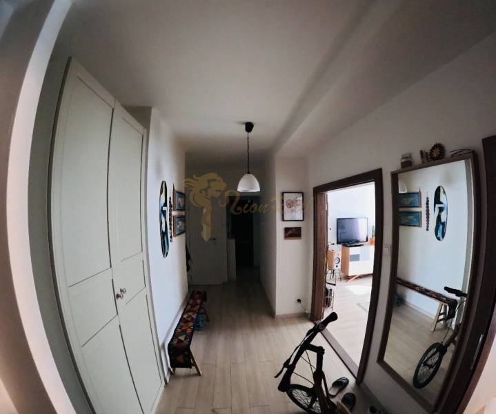 Veľký 2-izb. byt v tehlovom dome, Ružová dolina, Ružinov časť Nivy - Chodba v 2-izbovom byte s podlahou s dreveným dekorom, kreditom a bicyklom.