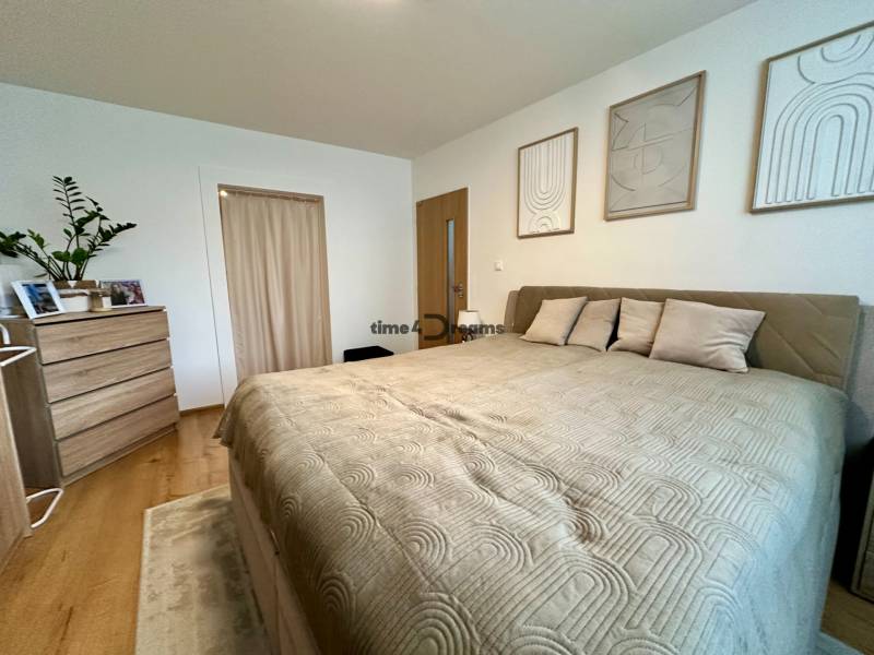 Na predaj: Priestranný rodinný dom v tichej lokalite obce Červeník - Spálňa s veľkou posteľou, komodou a dekoráciami v rodinnom dome.