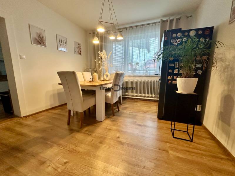 Na predaj: Priestranný rodinný dom v tichej lokalite obce Červeník - Jedáleň v rodinnom dome s podlahou s dreveným dekorom a stolom so štyrmi stoličkami.