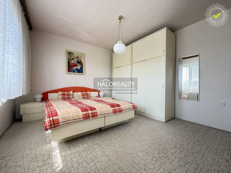 Predaj, rodinný dom Oslany - EXKLUZÍVNE HALO REALITY - Spálňa v rodinnom dome s veľkou skriňou, posteľou a obrazom na stene.