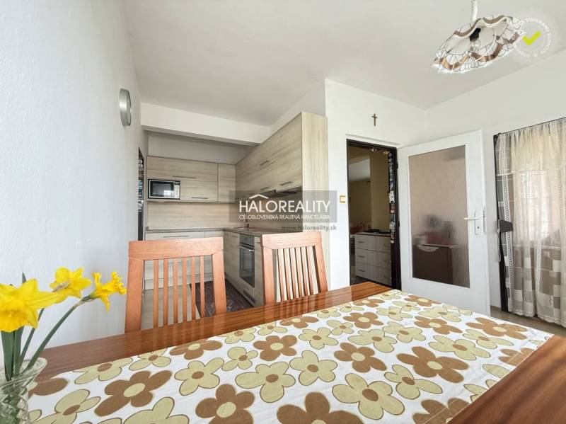 Predaj, rodinný dom Oslany - EXKLUZÍVNE HALO REALITY - Jasná kuchyňa v rodinnom dome s dreveným nábytkom a dekoratívnym stolným obrusom.