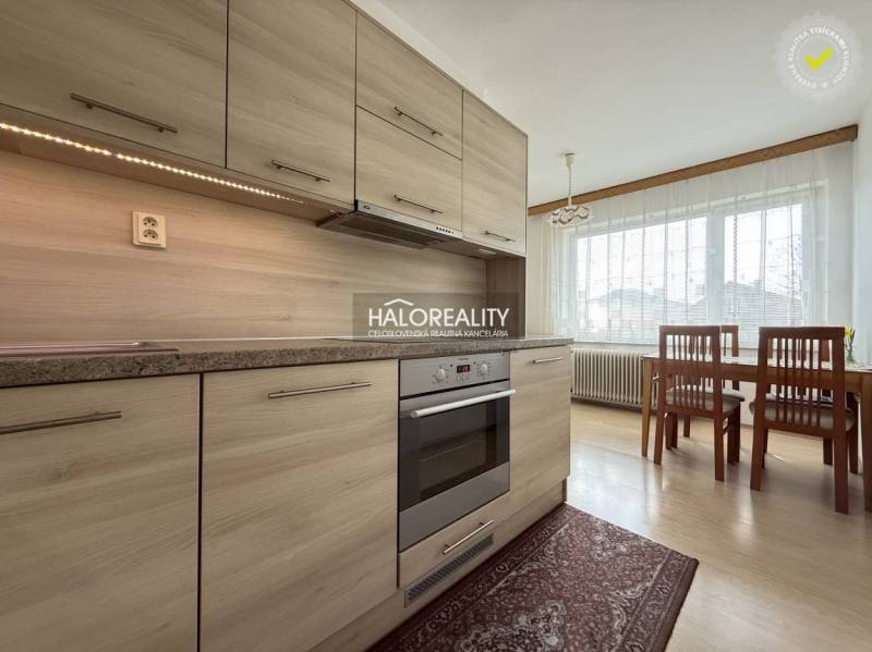 Predaj, rodinný dom Oslany - EXKLUZÍVNE HALO REALITY - Kuchyňa v rodinnom dome s podlahou s dreveným dekorom a jedálenským stolom.