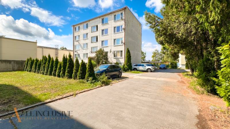 3 IZBOVÝ BYT PRI MESTSKOM PARKU | TOPOĽČANY - Pohľad na bytový dom na Stummerovej ulici v Topoľčanoch obklopený zeleňou a parkoviskom.