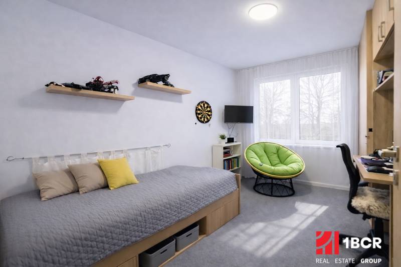 EXKLUZÍVNY 3-IZBOVÝ BYT V SÚKROMNOM KOMPLEXE |2x PARKING | NA PIESKU,  - Detská izba v 3-izbovom byte s posteľou, hračkami a zeleným kreslom.
