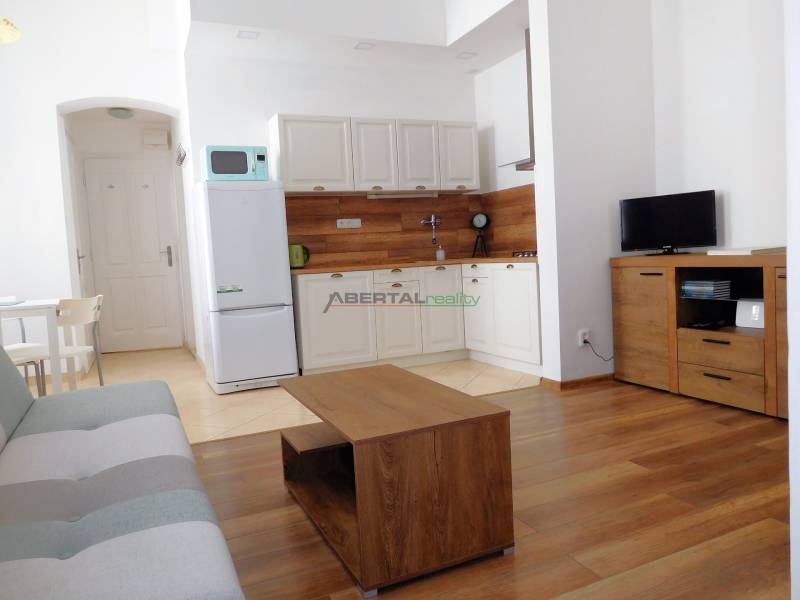 Predaj - štýlový 1,5i byt  v srdci Starého Mesta - Marianska, BA - Obývacia izba s kuchynským kútom v 2-izbovom byte s podlahou s dreveným dekorom.