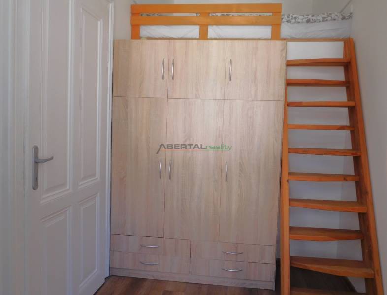 Predaj - štýlový 1,5i byt  v srdci Starého Mesta - Marianska, BA - V 2-izbovom byte je šatníková skriňa s posteľou a drevenými schodmi.