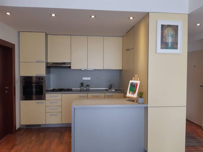 3 izb. byt v úplnom centre pri Šafárikovom námestí - Kuchyňa v 3-izbovom byte s bledými skrinkami a podlahou s dreveným dekorom.