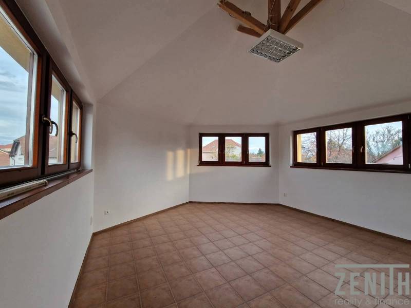 Výnimočný investičný priestor v centre Dunajskej Stredy - Interiér obchodných priestorov s dlažbou a veľkými oknami, poskytujúci dostatok denného svetla.