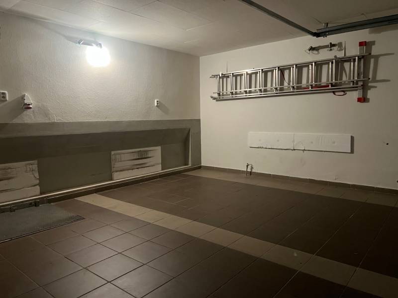 7 izb. rodinný dom s 2 - garážou neďaleko Horského parku - Garáž v rodinnom dome s keramickou dlažbou a rebríkom na stene.