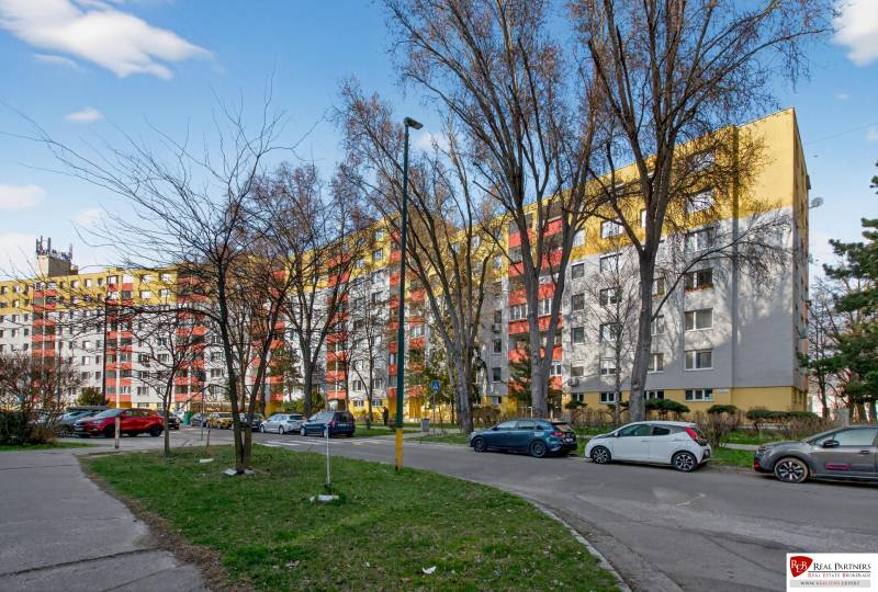 Ponúka na predaj 4 izb. byt na ul. Ševčenkova v Petržalke - Panelák na Ševčenkovej ulici v Petržalke, Bratislava, s autami na parkovisku.
