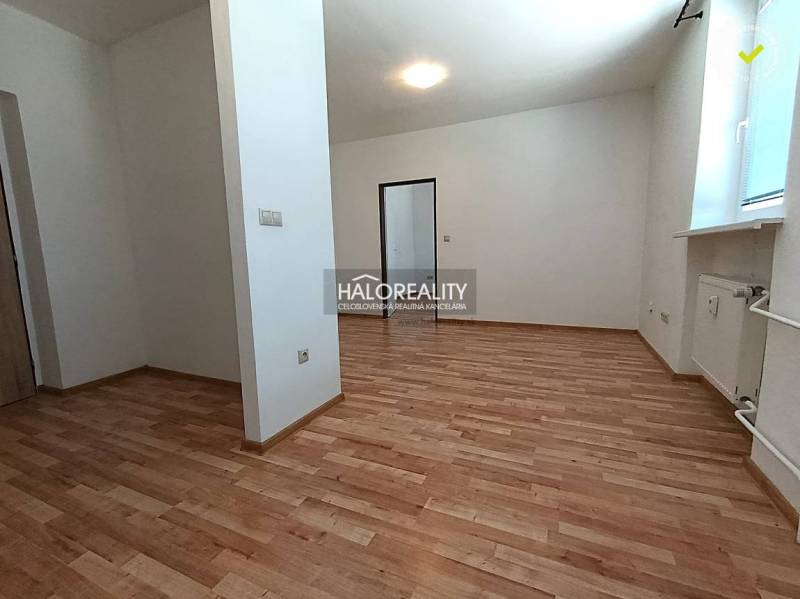 Prenájom, dvojizbový byt Nováky - NOVOSTAVBA - Priestranná miestnosť v 2-izbovom byte s podlahou s dreveným dekorom a bielymi stenami.