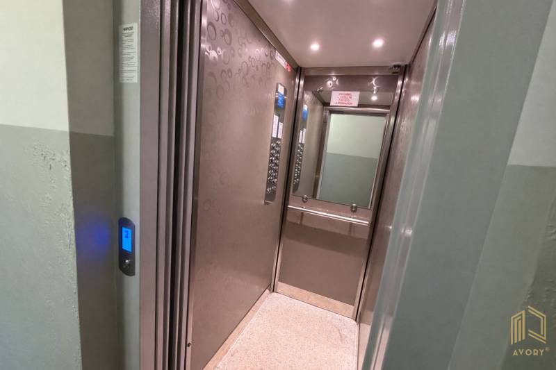 NA PRENÁJOM GARSÓNKA S BALKÓNOM, SENICA, ŠTEFÁNIKOVA UL. - Vnútro moderného výťahu v garsónke s kovovými stenami a zrkadlom.