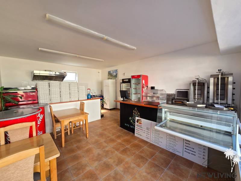 *NA PRENÁJOM* zariadená PIZZA / kebab - Mierová ul. - Interiér gastro priestorov s pultom, chladiacimi vitrínami a stohom krabíc na pizzu.
