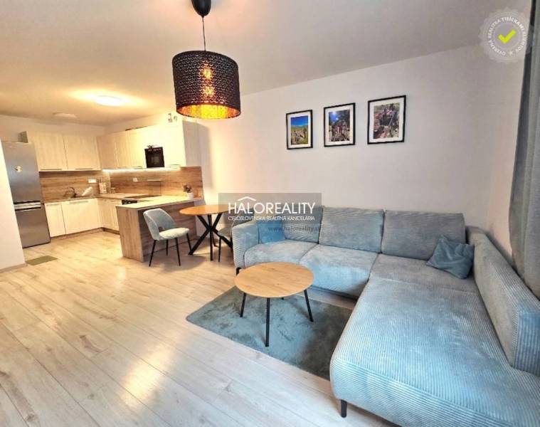 Predaj, dvojizbový byt Bratislava Podunajské Biskupi... - Obývacia izba v 2-izbovom byte s kuchynským kútom a podlahou s dreveným dekorom.