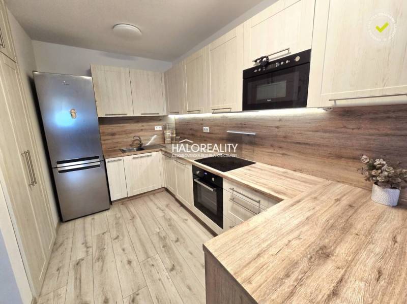 Predaj, dvojizbový byt Bratislava Podunajské Biskupi... - Kuchyňa v 2-izbovom byte s podlahou s dreveným dekorom a svetlým nábytkom.