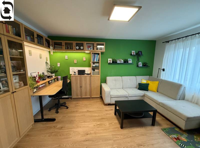 4 Izbový byt na Kríkovej ulici na predaj - Obývacia izba so sedačkou, pracovným stolom a podlahou s dreveným dekorom v 4-izbovom byte.