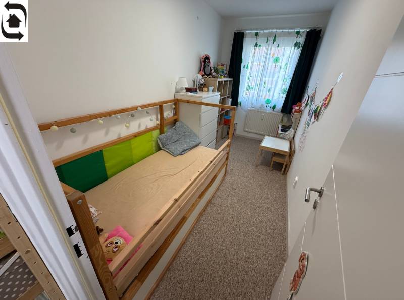 4 Izbový byt na Kríkovej ulici na predaj - Detská izba v 4-izbovom byte s posteľou, komodou a farebnými závesmi.