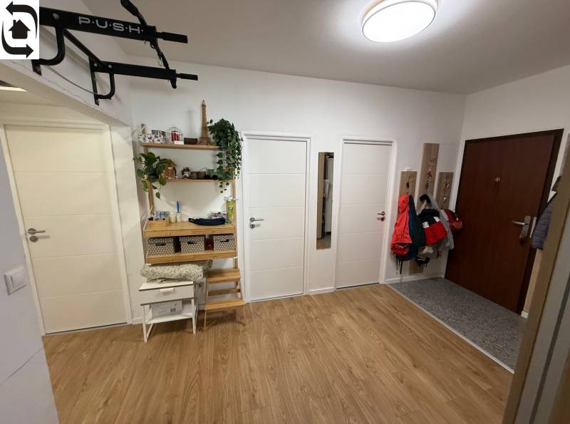 4 Izbový byt na Kríkovej ulici na predaj - Vstupná hala so štyrmi dverami, podlahou s dreveným dekorom a vešiakmi v 4-izbovom byte.