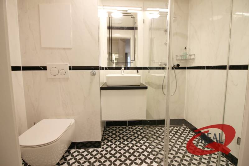 **SKVELÁ INVESTÍCIA**REZIDENCIA OPERA**KÚPELE TURČIANSKE TEPLICE** - Kúpeľňa v 2-izbovom byte s čiernobielou dlažbou a sprchovacím kútom.