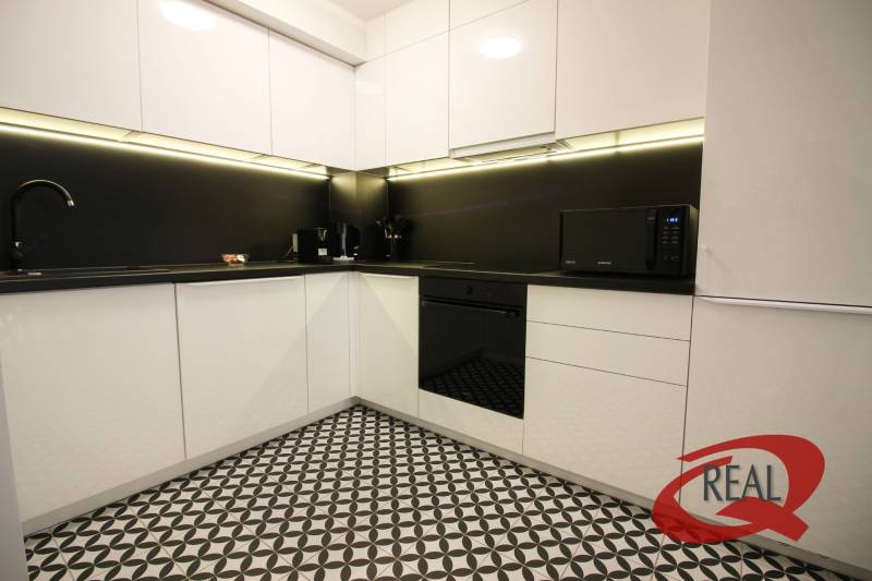 **SKVELÁ INVESTÍCIA**REZIDENCIA OPERA**KÚPELE TURČIANSKE TEPLICE** - Kuchyňa v 2-izbovom byte s čiernobielou dlažbou a modernými spotrebičmi.