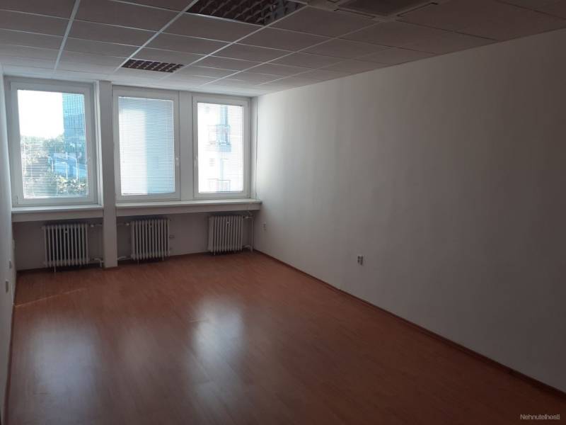Klimatizovaná kancelária 30 m2 pri POLUS-e na Pluhovej ul. - Prázdny kancelársky priestor s podlahou s dreveným dekorom a veľkými oknami.