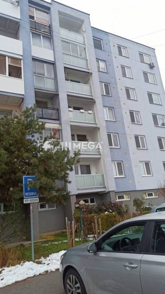 Na predaj 3 izbový byt na vynikajúcej adrese - Vranov nad Topľou - Bytový dom na Lúčnej ulici vo Vranove nad Topľou, so zaparkovaným autom a zasneženou krajinou.