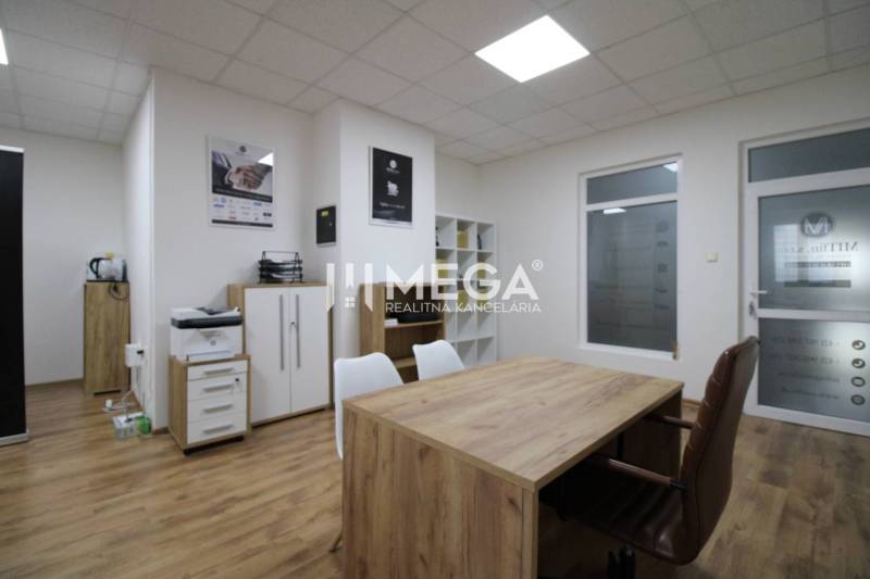 NA PRENÁJOM - obchodný priestor v OD Laborec, pešia zóna mesta Humenné - Obchodné priestory so stolom, podlahou s dreveným dekorom a bielymi stenami.