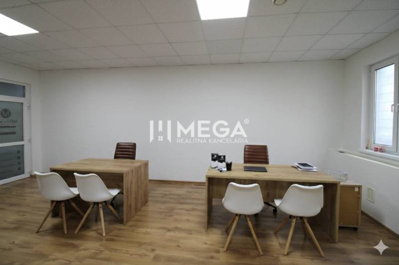 NA PRENÁJOM - obchodný priestor v OD Laborec, pešia zóna mesta Humenné - Kancelária s dreveným dekorom podlahy a dvoma stolmi, vybavená bielymi a hnedými stoličkami.