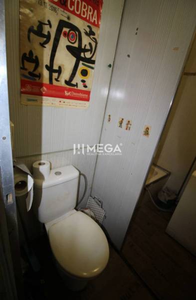 NA PRENÁJOM - Garsónka v pôvodnom stave na Sídlisku III v meste Humenn - Kúpeľňa v Rekreačnom apartmáne s toaletou a dekoračným plagátom na stene.