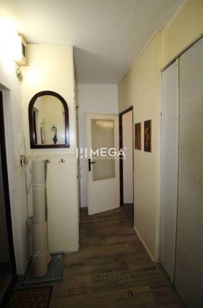 NA PRENÁJOM - Garsónka v pôvodnom stave na Sídlisku III v meste Humenn - Chodba v rekreačnom apartmáne s podlahou s dreveným dekorom, zrkadlom a dekoratívnym zrkadlom.