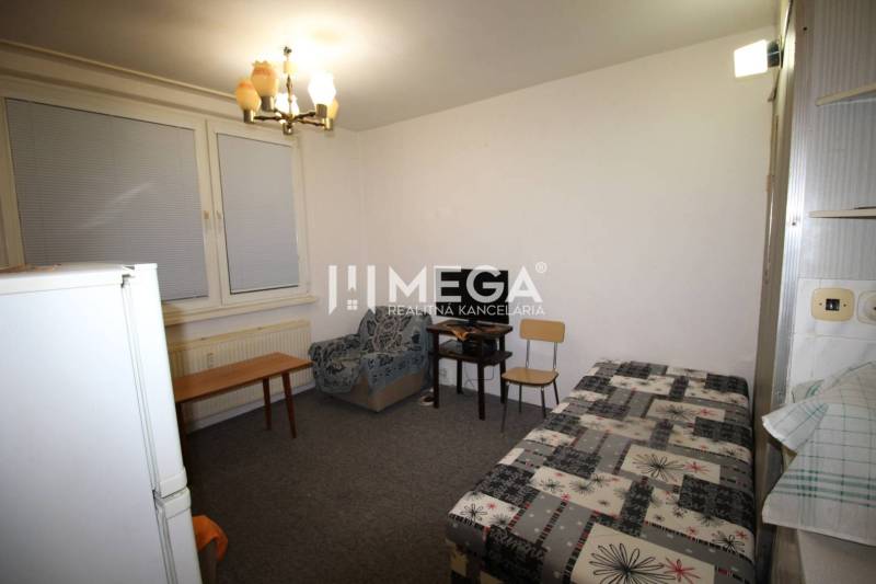 NA PRENÁJOM - Garsónka v pôvodnom stave na Sídlisku III v meste Humenn - Rekreačný apartmán so sedačkou, posteľou a stolom, jednoduchý interiér.