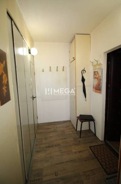 NA PRENÁJOM - Garsónka v pôvodnom stave na Sídlisku III v meste Humenn - Chodba v rekreačnom apartmáne s podlahou s dreveným dekorom, vešiakmi a zrkadlom.