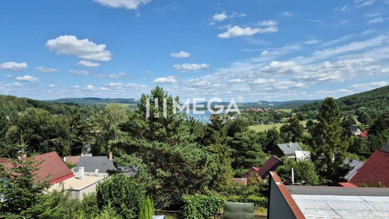 PREDAJ REKREAČNEJ CHATY NA DOMAŠI časť DOBRÁ - Výhľad z chaty na Vodárenskej ulici v Kvakovciach, obklopený kopcami a zeleňou.