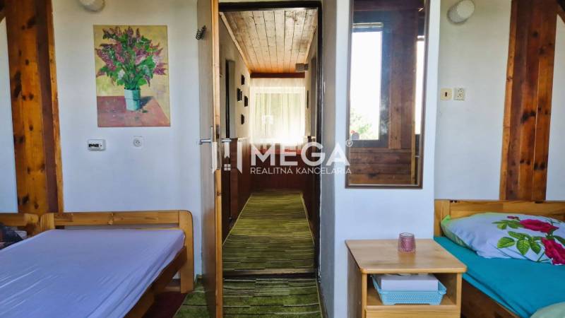 PREDAJ REKREAČNEJ CHATY NA DOMAŠI časť DOBRÁ - Dva jednolôžkové postele, obraz, zrkadlo a pohľad do svetlej chodby chaty.