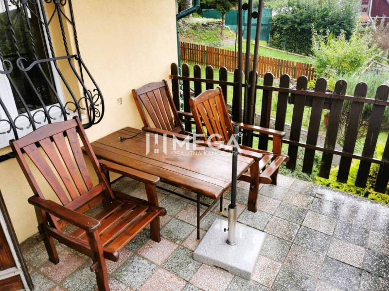 PREDAJ REKREAČNEJ CHATY NA DOMAŠI časť DOBRÁ - Drevený nábytok na terase chaty na Vodárenskej ulici v Kvakovciach, s výhľadom na záhradu.