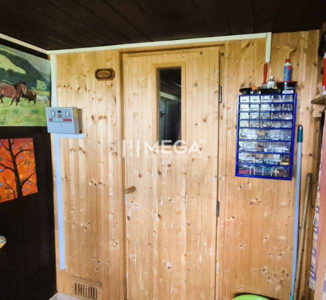 PREDAJ REKREAČNEJ CHATY NA DOMAŠI časť DOBRÁ - Drevené dvere v chate, s vešiakom na náradie a obrázkom koní na stene.