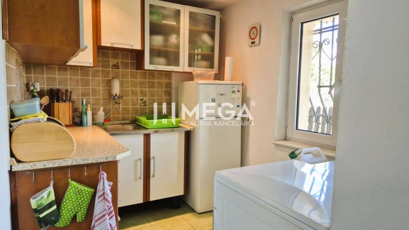 PREDAJ REKREAČNEJ CHATY NA DOMAŠI časť DOBRÁ - Kuchyňa v Chate s pracovnou doskou, skriňami, práčkou a mrazničkou.