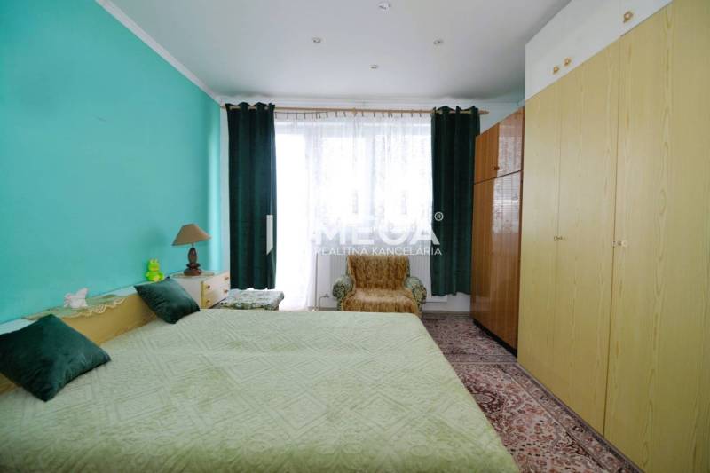 PREDAJ RODINNÉHO DOMU v obci LACKOVCE (HE) - Spálňa v rodinnom dome s modrou stenou, posteľou a skriňou.