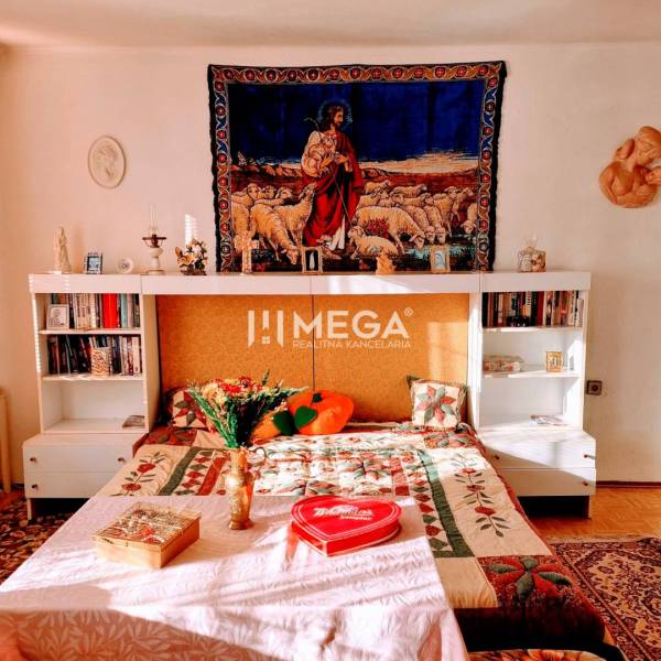 SKVELÁ CENA - výnimočný  rodinný dom, Kamenica nad Cirochou - Spálňa rodinného domu s posteľou, tapisériou a kvetinovou dekoráciou.