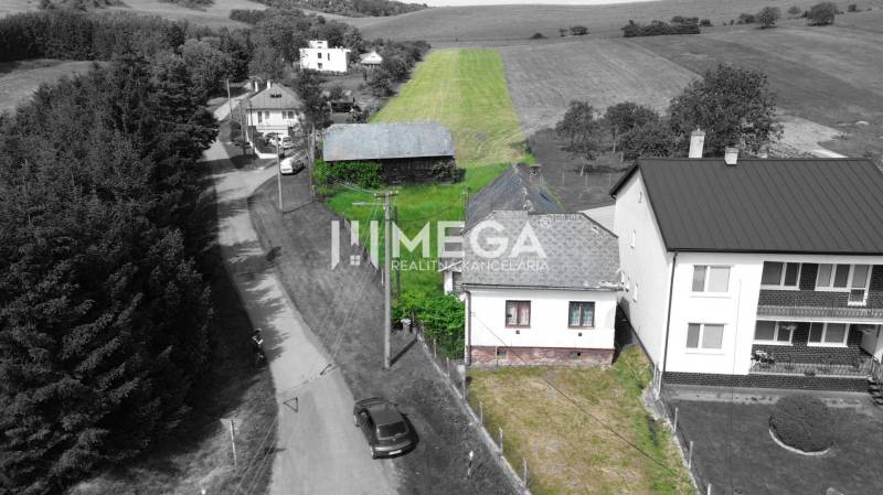 EXKLUZÍVNE NA PREDAJ: Rozsiahly pozemok, Ondavské Matiašovce - Pozemky - bývanie v Ondavských Matiašovciach s domami, cestou a zeleným poliom v pozadí.