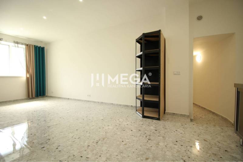 NA PRENÁJOM: Kancelárske priestory + 3-izbový apartmán – Košice - Priestranná izba v budove s kachličkovou podlahou a policovým regálom.