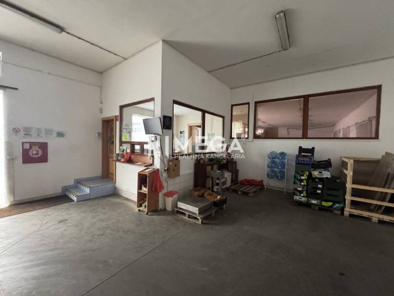 NA PREDAJ: OBJEKT VHODNÝ NA PODNIKANIE-SKLADOVANIE A SLUŽBY - Interiér skladov a hál s kanceláriou, schodmi, paletami a fľašami na vodu.