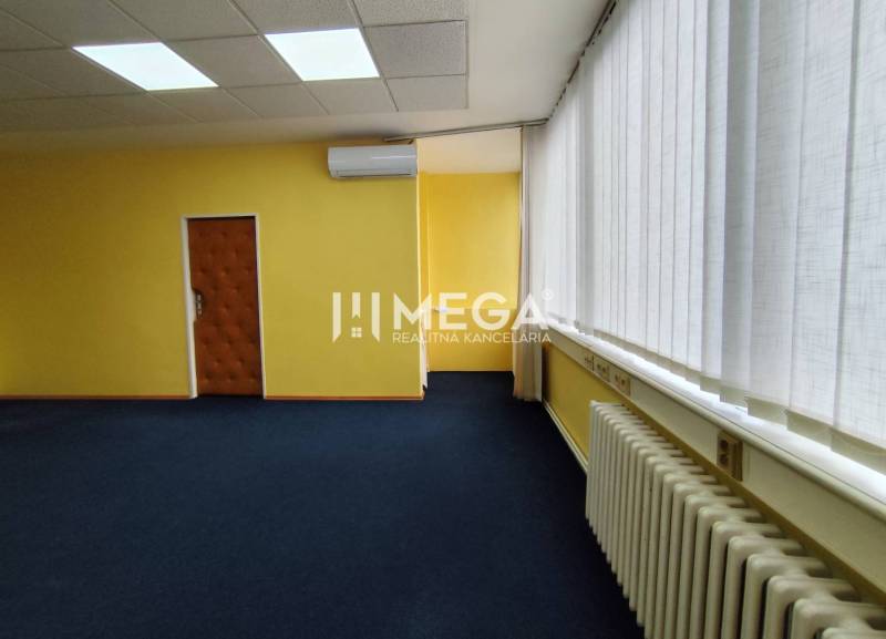 NA PRENÁJOM - kancelárske priestory v cente mesta Michalovce - Interiér kancelárie s modrým kobercom, žltými stenami a klimatizáciou.