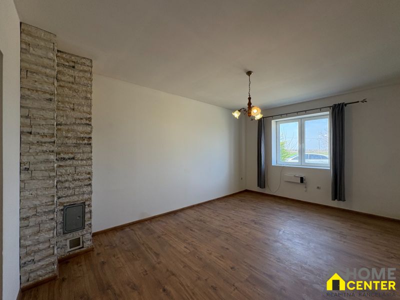 PREDAJ: Rodinný dom po rekonštrukcii /700 m2 pozemok/ Zemianska Olča - Interiér rodinného domu s podlahou s dreveným dekorom a kamennou stenou.