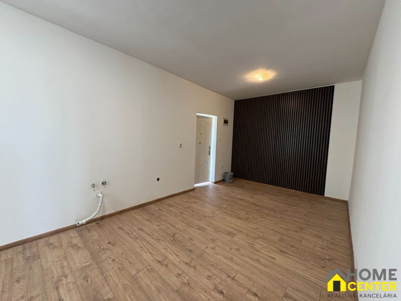 PREDAJ: Rodinný dom po rekonštrukcii /700 m2 pozemok/ Zemianska Olča - Izba v rodinnom dome s podlahou s dreveným dekorom a výraznou čiernou stenou.