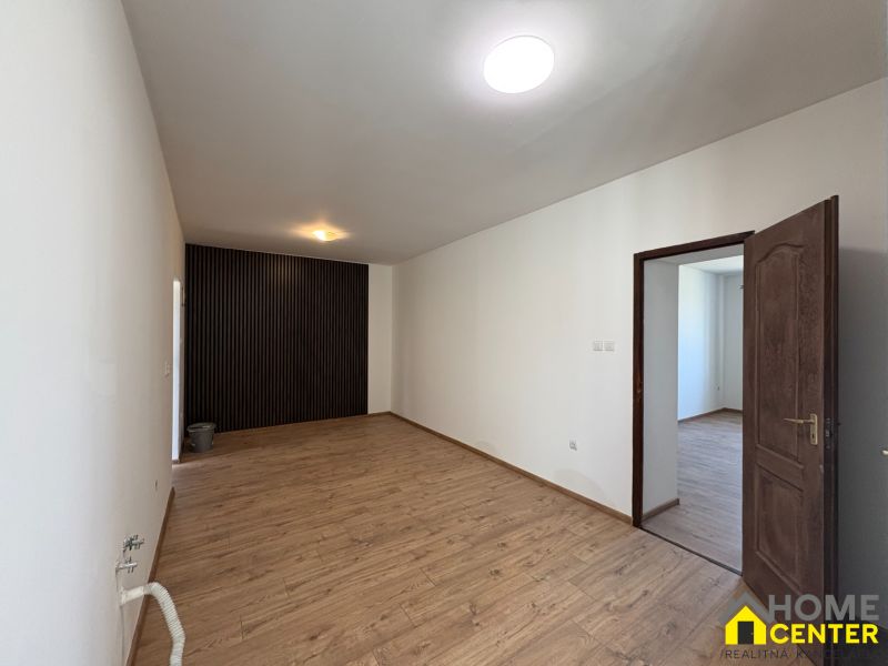PREDAJ: Rodinný dom po rekonštrukcii /700 m2 pozemok/ Zemianska Olča - Interiér rodinného domu s podlahou s dreveným dekorom a bielymi stenami.