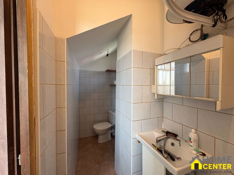 PREDAJ: Rodinný dom po rekonštrukcii /700 m2 pozemok/ Zemianska Olča - Kúpeľňa v rodinnom dome s umývadlom a toaletou, obložená svetlými dlaždicami.