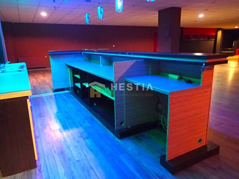 Veľký komerčný priestor 292 m2 priamo v centre mesta - Nočný bar s osvetleným pultom, drevenou podlahou a priestorom pre Obchodné priestory.